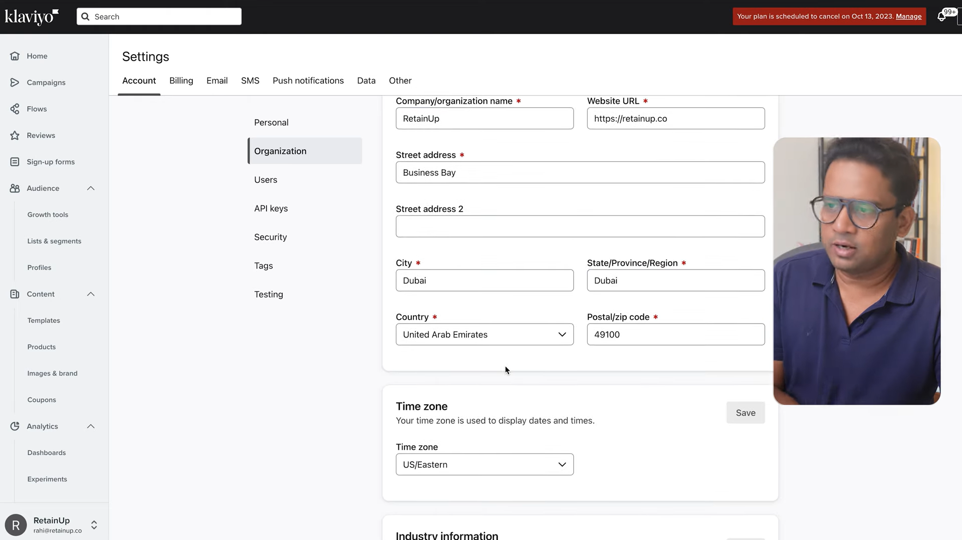 Klaviyo organization settings with business name and address fields, with presenter video