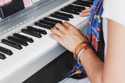 Hands playing a digital piano keyboard