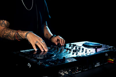 DJ mixing on a controller in a dark room