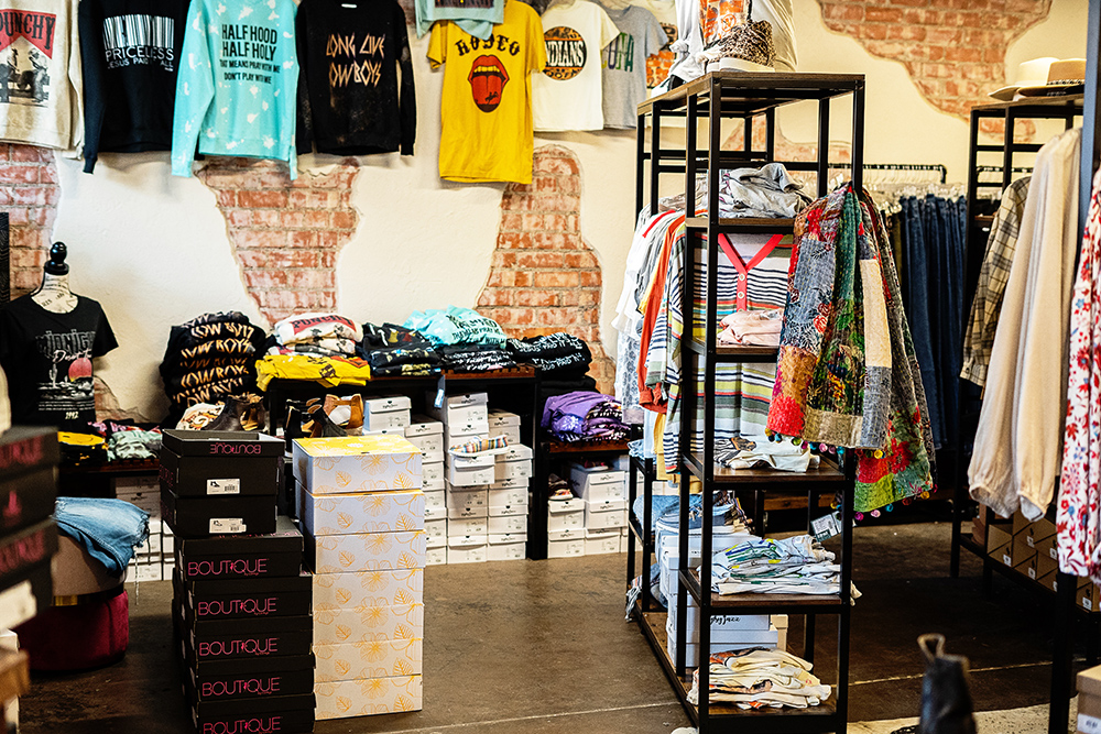 Graphic tees and racks inside Grace and Grit Boutique