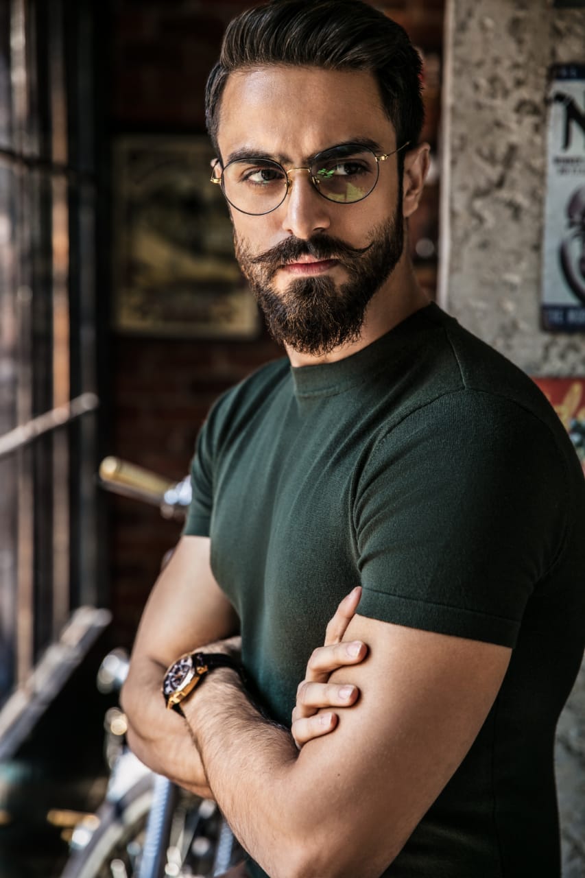Bearded man in glasses with arms crossed