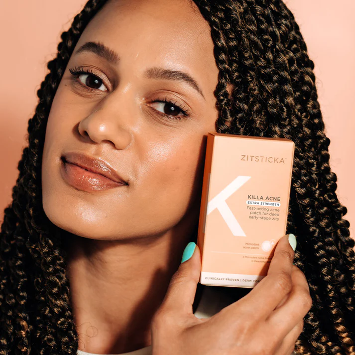 Woman holding a ZitSticka Killa acne patch kit