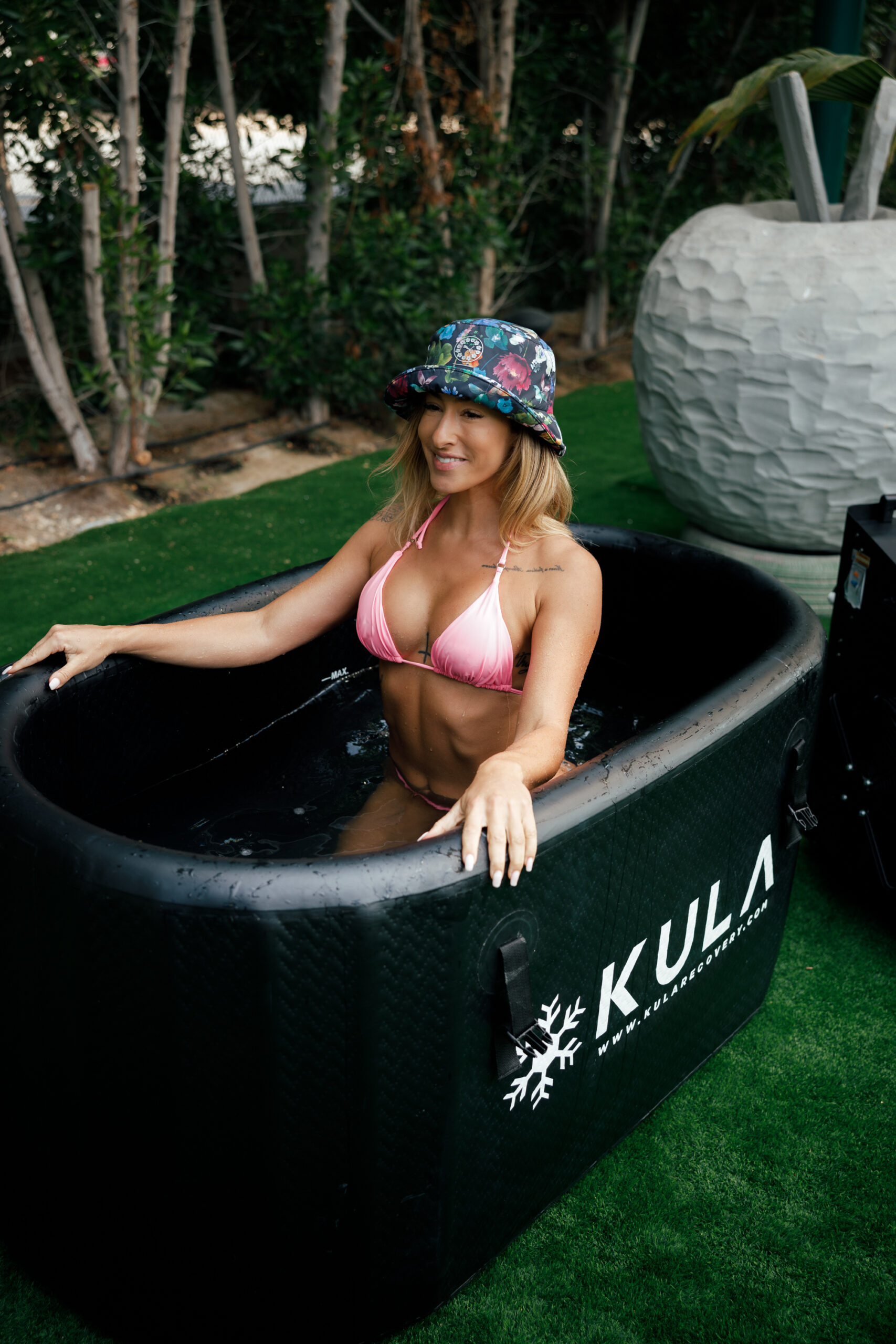 Woman sitting in a KULA oval cold plunge