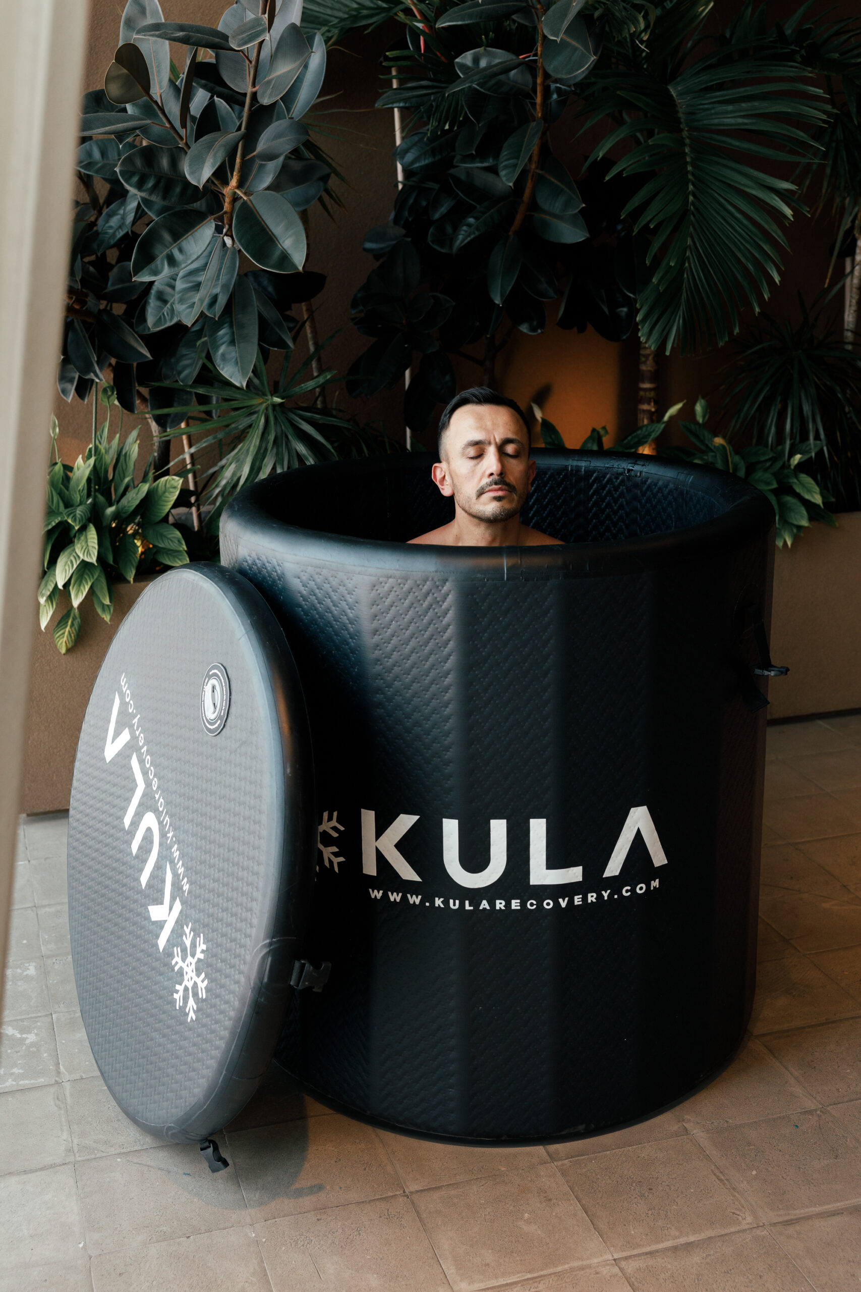 Man inside a KULA barrel cold plunge with the lid off