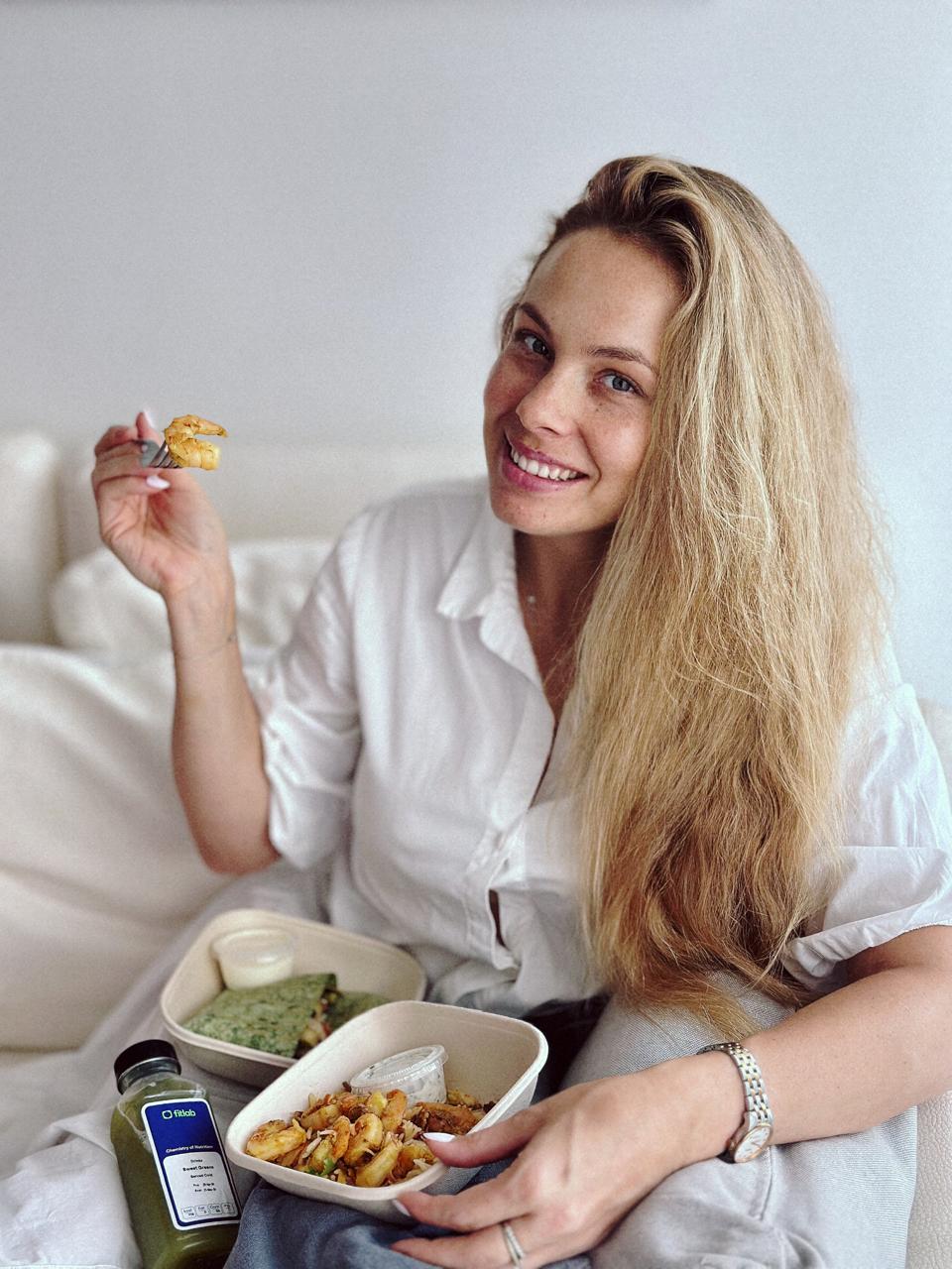 Woman eating a Fitlab meal on the sofa