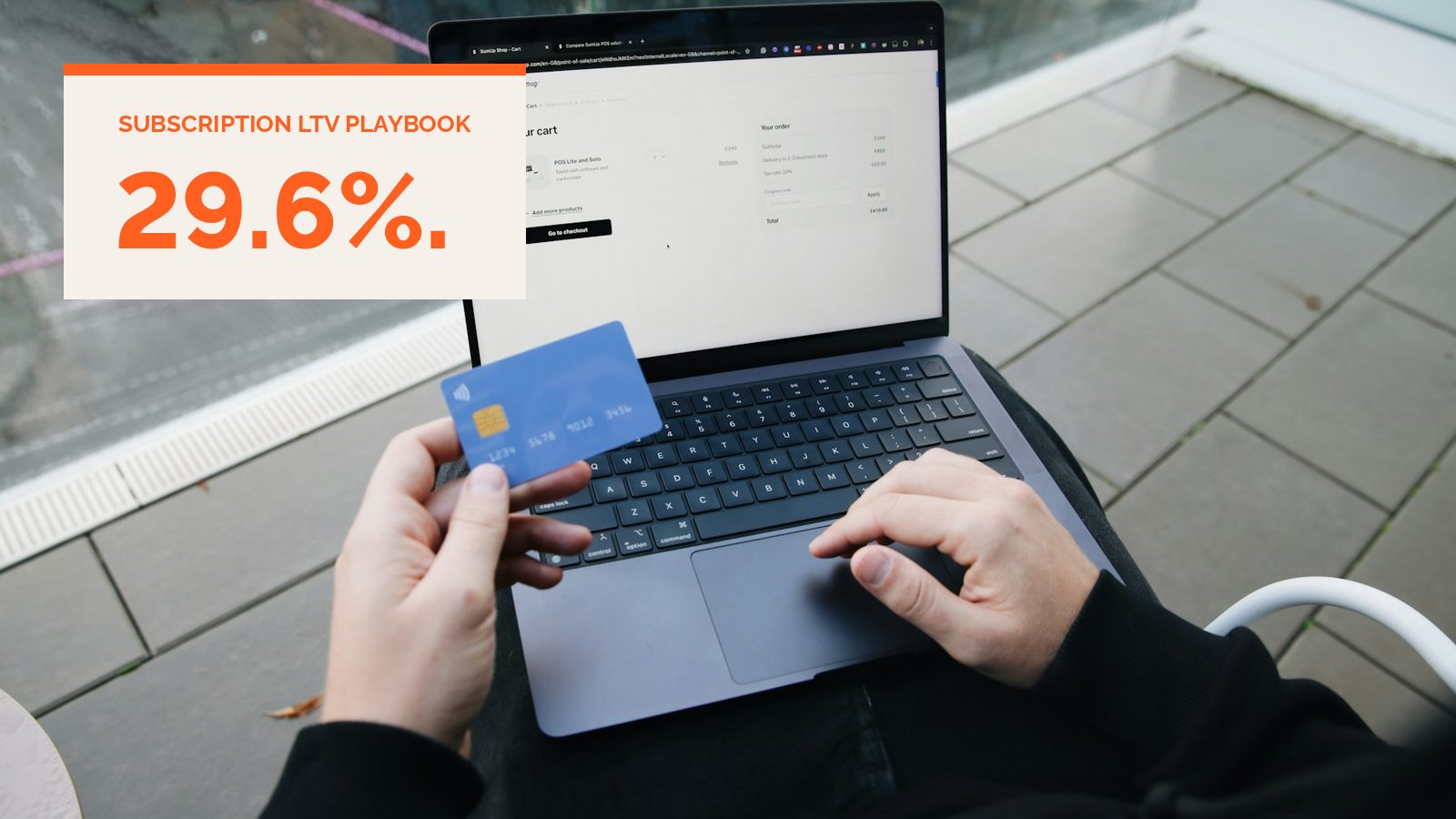 A person at a laptop holding a payment card